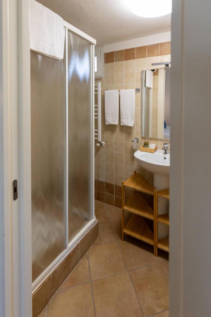 une salle de bain avec douche et lavabo dans l'établissement Riva di Palo Beach Hotel, à Ladispoli
