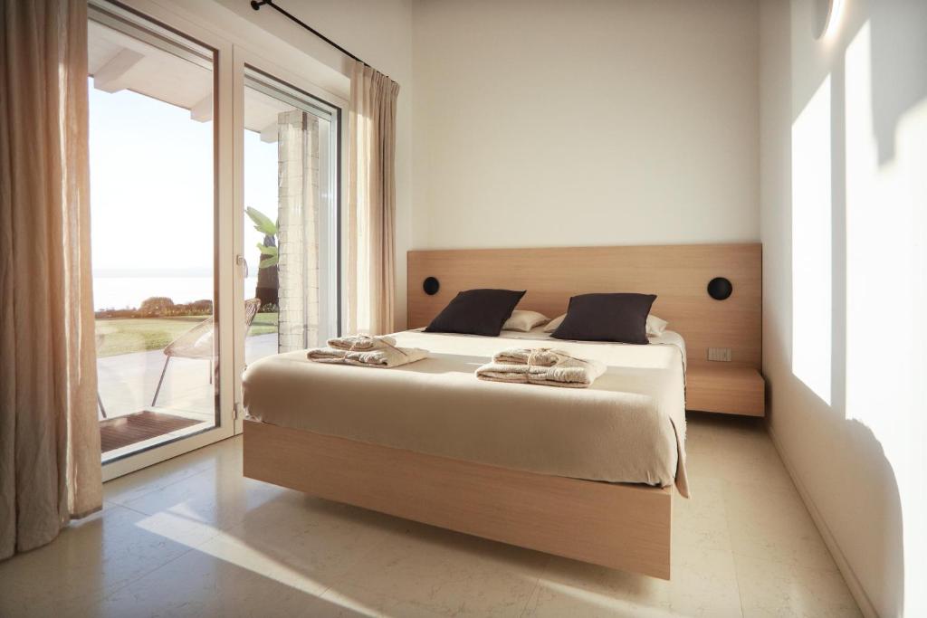 une chambre avec un grand lit et une grande fenêtre dans l'établissement Villa F, à Bardolino