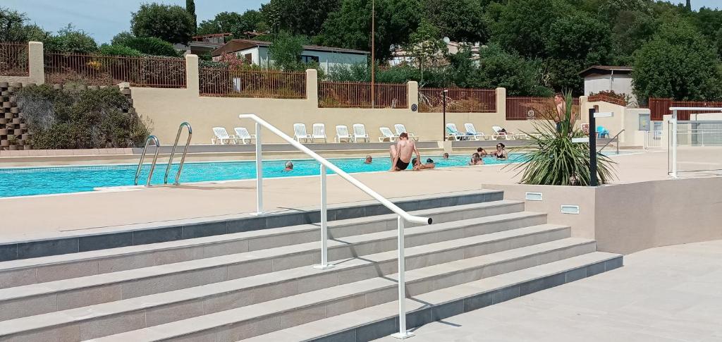 une piscine avec des escaliers et des personnes dans l'eau dans l'établissement Le Bungalow Bleu Domaine des Canebieres Golfe de St Tropez, au Muy