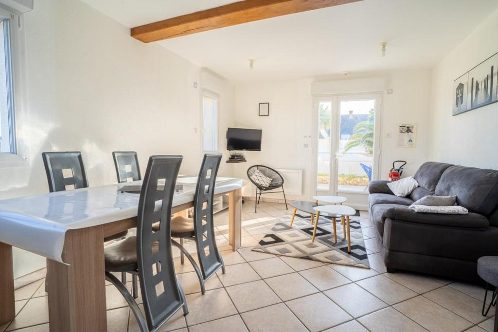 un salon avec une table, des chaises et un canapé dans l'établissement Omaha gîtes, à Vierville-sur-Mer
