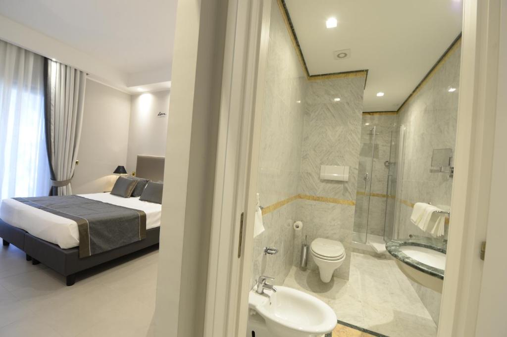 une chambre avec un lit et une salle de bain avec douche dans l'établissement Hotel Cerere, à Paestum