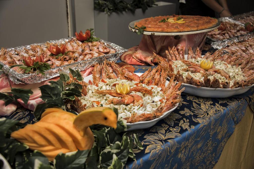 - un buffet de fruits de mer et d'autres plats sur une table dans l'établissement Strand Hotel Colorado, à Lido di Savio