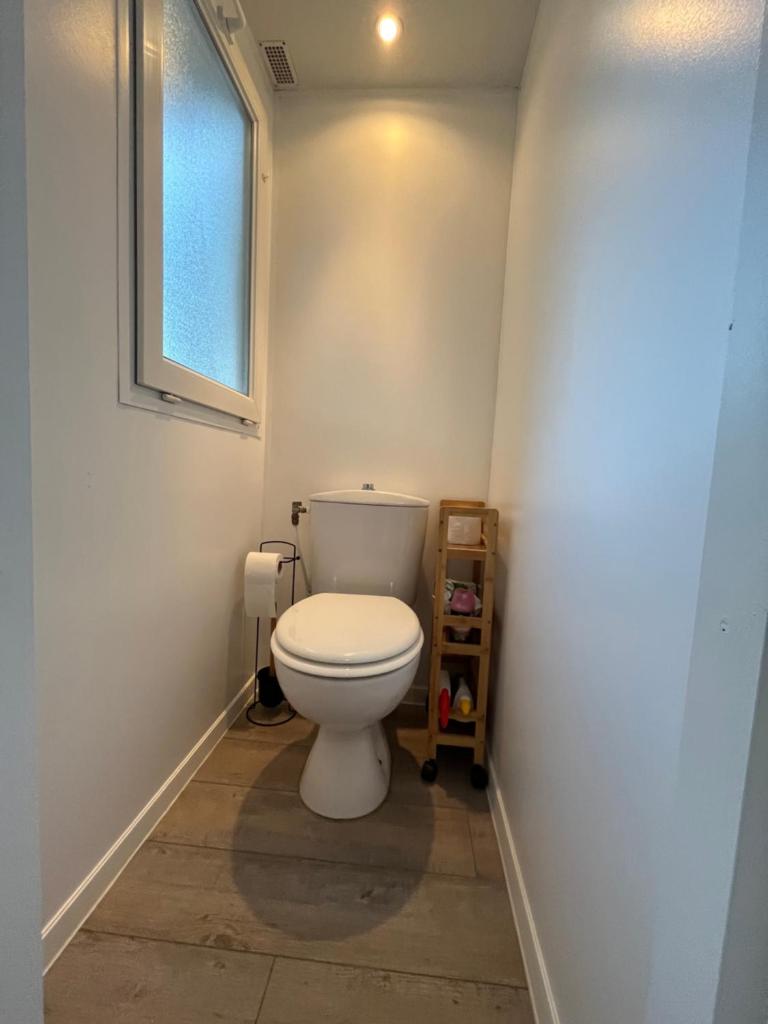 une salle de bain avec toilettes et fenêtre dans l'établissement Mobil-home Camping Oasis, à Roquebrune-sur Argens