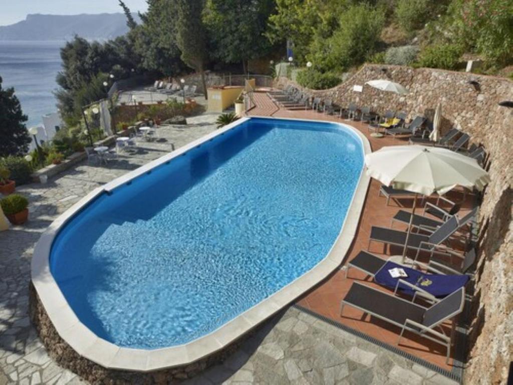une grande piscine avec des chaises et un parasol dans l'établissement Best Western Hotel Acqua Novella, à Spotorno