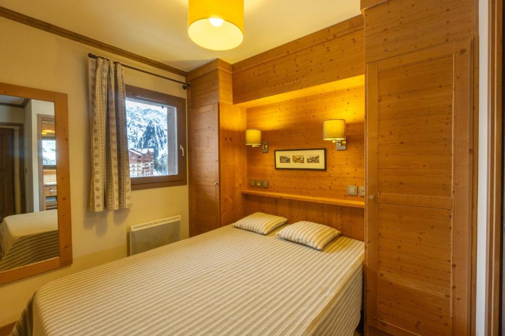une chambre avec un lit dans une pièce avec une fenêtre dans l'établissement Appartement B56 - Eco Le Ruitor, à Sainte-Foy-Tarentaise