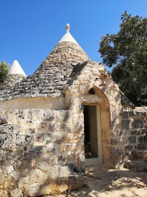 - un petit bâtiment en pierre avec une fenêtre et une porte dans l'établissement Eremo di San Giusto - Trullo Vista Mare, à Ostuni