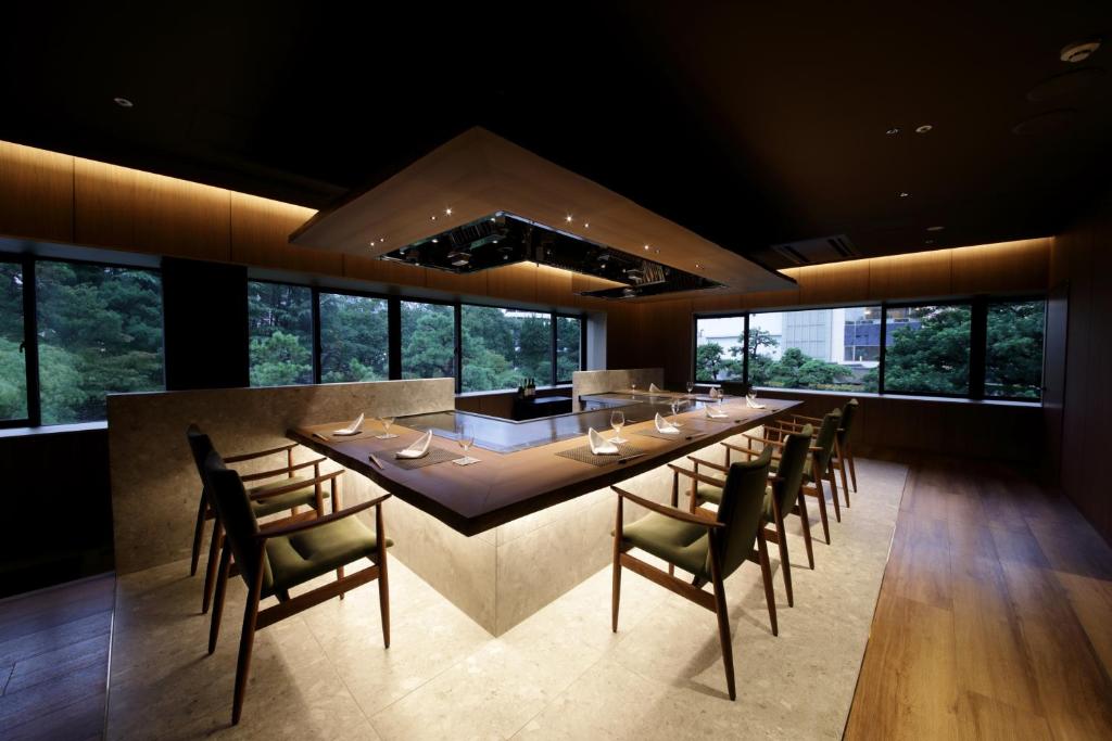 une grande salle à manger avec une longue table et des chaises dans l'établissement Suisui Garden Ryokan (in the Art Hotel Kokura New Tagawa), à Kitakyūshū