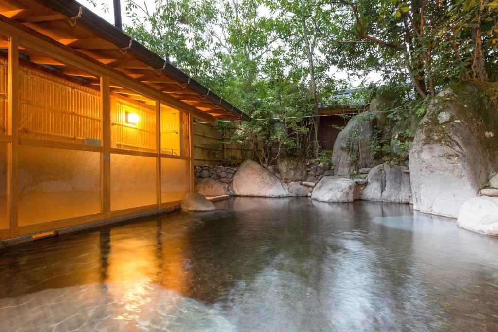 une piscine d'eau à côté d'un bâtiment dans l'établissement Yufuin Onsen Hinoharu Ryokan, à Yufu