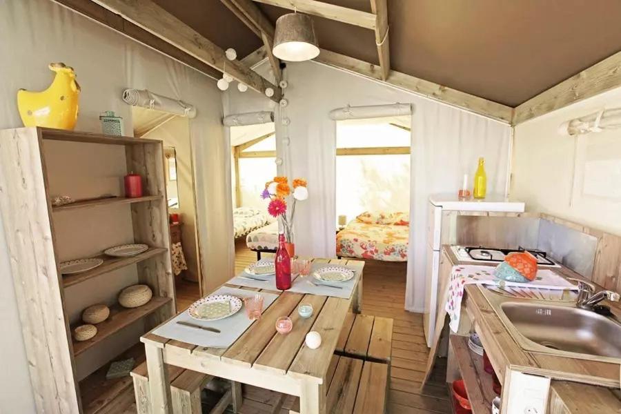 - une cuisine avec une table et un évier dans la chambre dans l'établissement maeva Respire Cottage de Brocéliande, à Caro