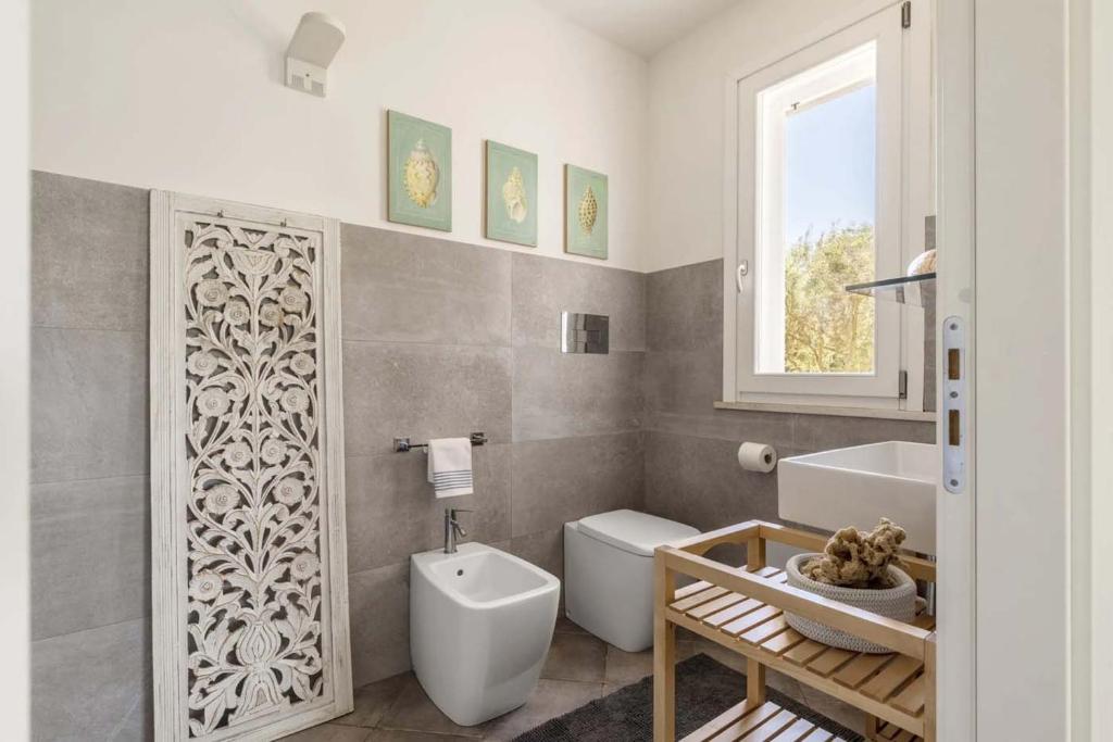 une salle de bain avec toilettes, baignoire et lavabo dans l'établissement Villa Le Pigne, à Favignana 20 autres photos