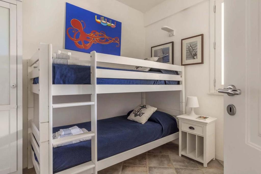 - une chambre avec 2 lits superposés et des draps bleus dans l'établissement Villa Le Pigne, à Favignana