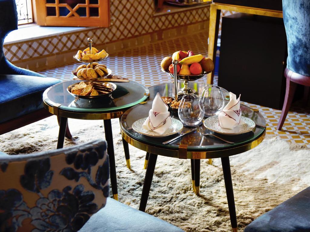 Deux tables avec de la nourriture et des fruits au-dessus dans l'établissement Riad El Amine Fès - Historic Hotels Worldwide, à Fès