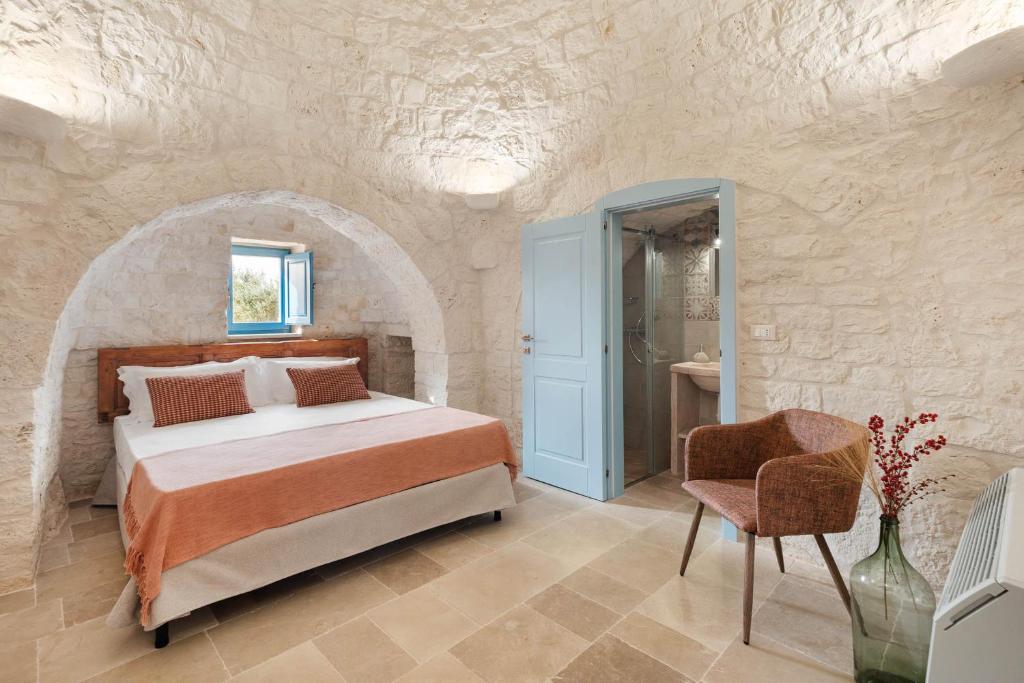 une chambre avec un lit et une chaise dans l'établissement Trullo Pia, à Monopoli