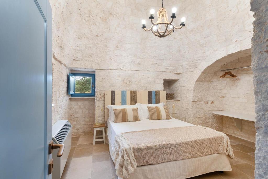 une chambre avec un lit dans un mur de pierre dans l'établissement Trullo Pia, à Monopoli 26 autres photos