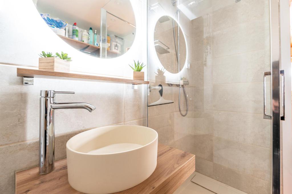 une salle de bain avec un lavabo blanc et une douche dans l'établissement Le Marmotton, à La Giettaz