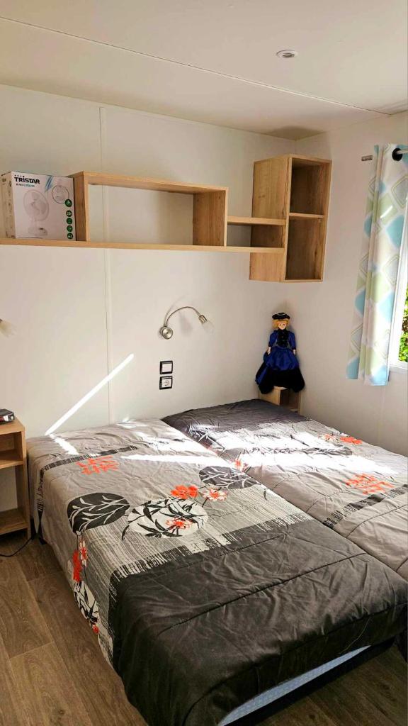une chambre avec un lit dans une pièce dans l'établissement Mobil home 653 tout confort 2ch au camping La Réserve, à Gastes