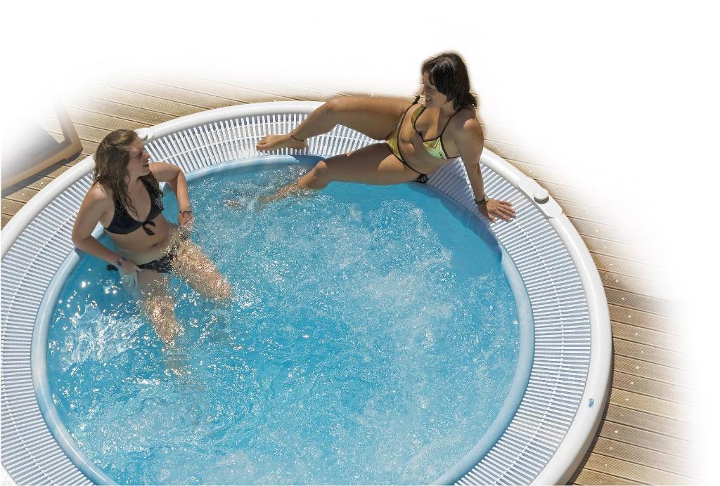 deux femmes sont dans une piscine dans l'établissement Hotel Victoria, à Bibione