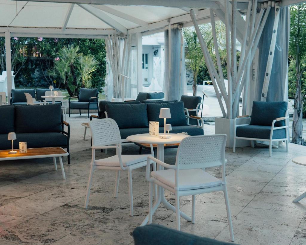 Elle comprend un coin salon avec des chaises, des tables et des chaises. dans l'établissement Relais Corte Degli Aragonesi, à Ischia