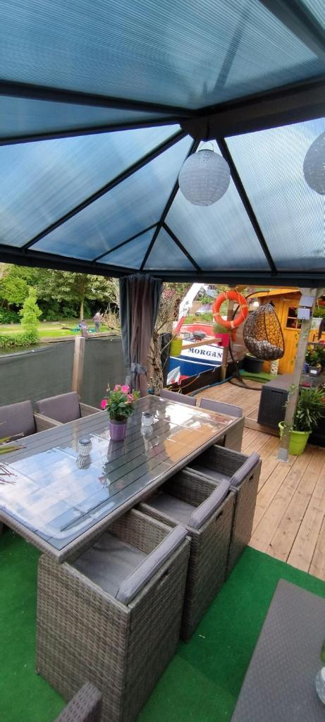 une terrasse avec une table et des chaises sous une tente dans l'établissement Péniche Morgane 2 SAS Les Bêtises, à Cambrai 31 autres photos