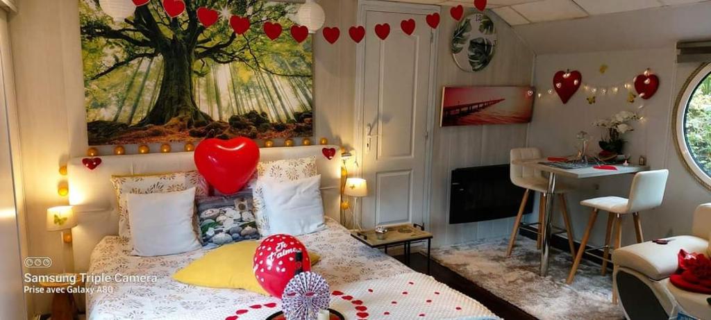 - une chambre avec un lit avec un cœur dans l'établissement Péniche Morgane 2 SAS Les Bêtises, à Cambrai