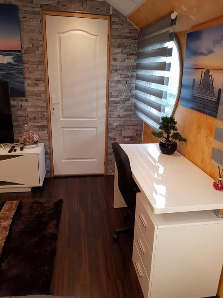 Cette chambre dispose d'un bureau et d'une porte blancs. dans l'établissement Péniche Morgane 2 SAS Les Bêtises, à Cambrai