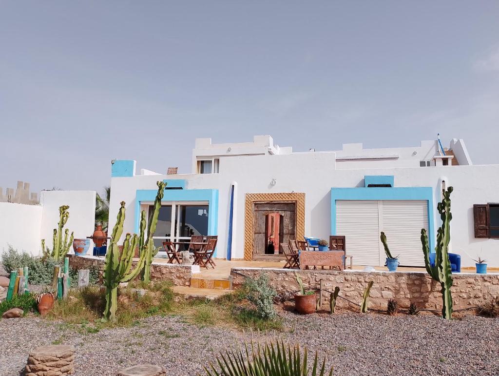 Cette maison présente des murs blancs et des touches de bleu. dans l'établissement Riad & Restaurant Ocean Beach Douira, à Agadir