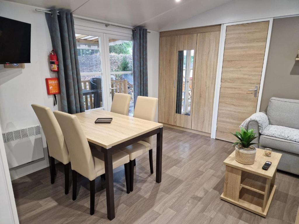 - une table à manger et des chaises dans le salon dans l'établissement Mobil home tout confort 3 chambres camping Les Pierres Couchées, à Saint-Brévin-les-Pins