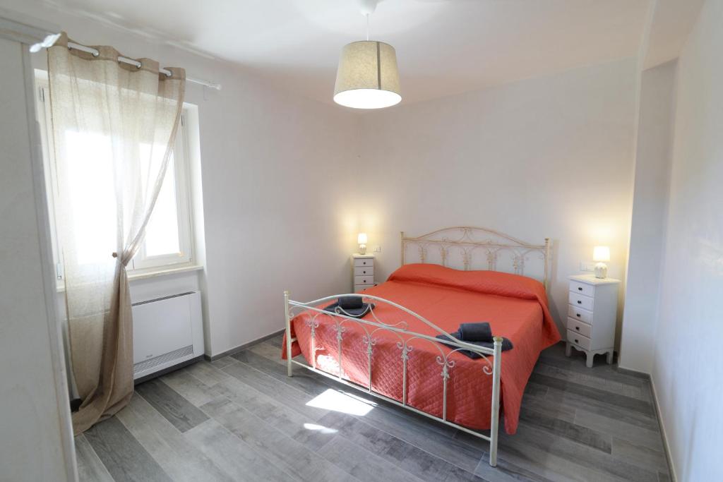 - une chambre avec un lit rouge et une fenêtre dans l'établissement Villa Elenik - Puglia Mia Apartments, à Triggianello