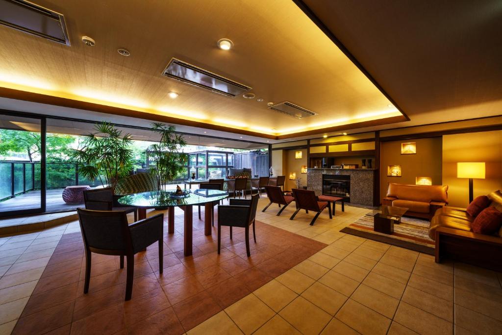 un grand salon avec une table et des chaises dans l'établissement Aburaya Tousen, à Yamanouchi