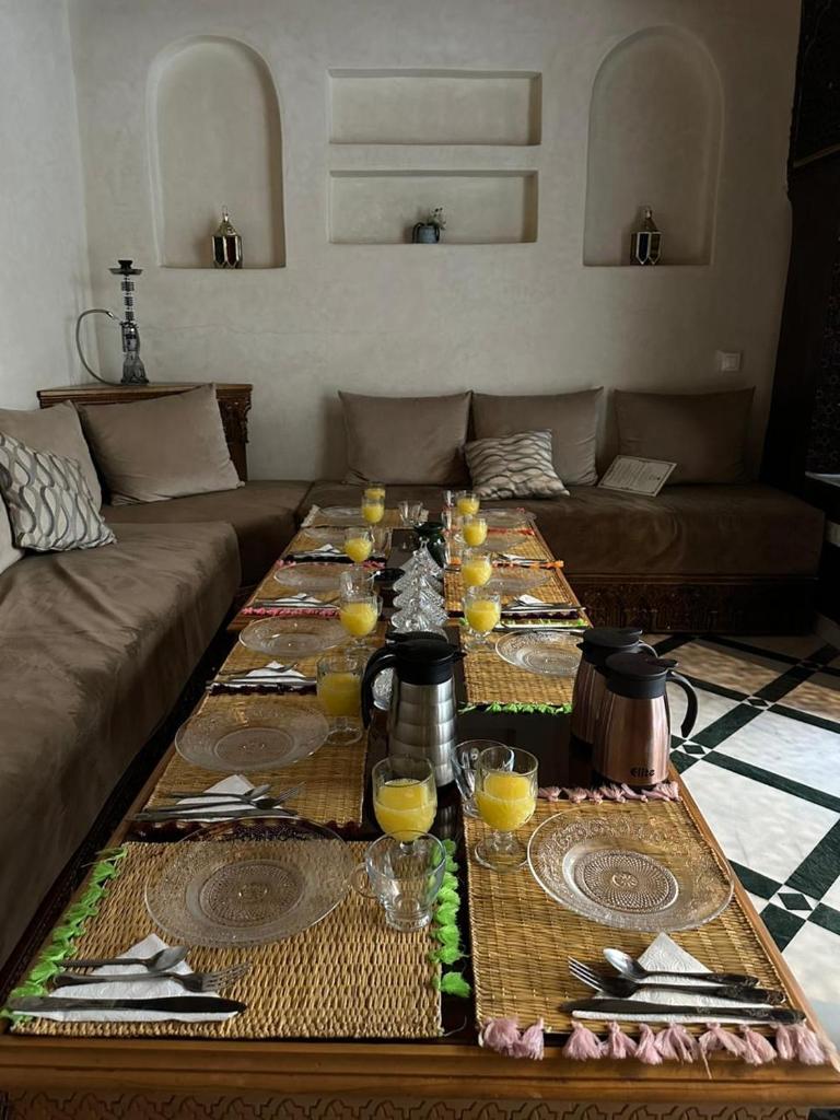 - un salon avec une table et des verres de jus d'orange dans l'établissement Riad Deluxe, à Marrakech
