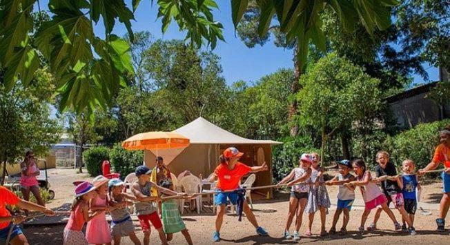 Un groupe d'enfants joue dans une corde dans l'établissement Joli Logement Climatisé 6 personnes Joli Camping à Agde, à Agde 19 autres photos
