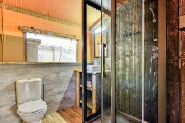 une salle de bain avec toilettes et douche en verre dans l'établissement Camping Saint-Lambert - Maeva, à Millau