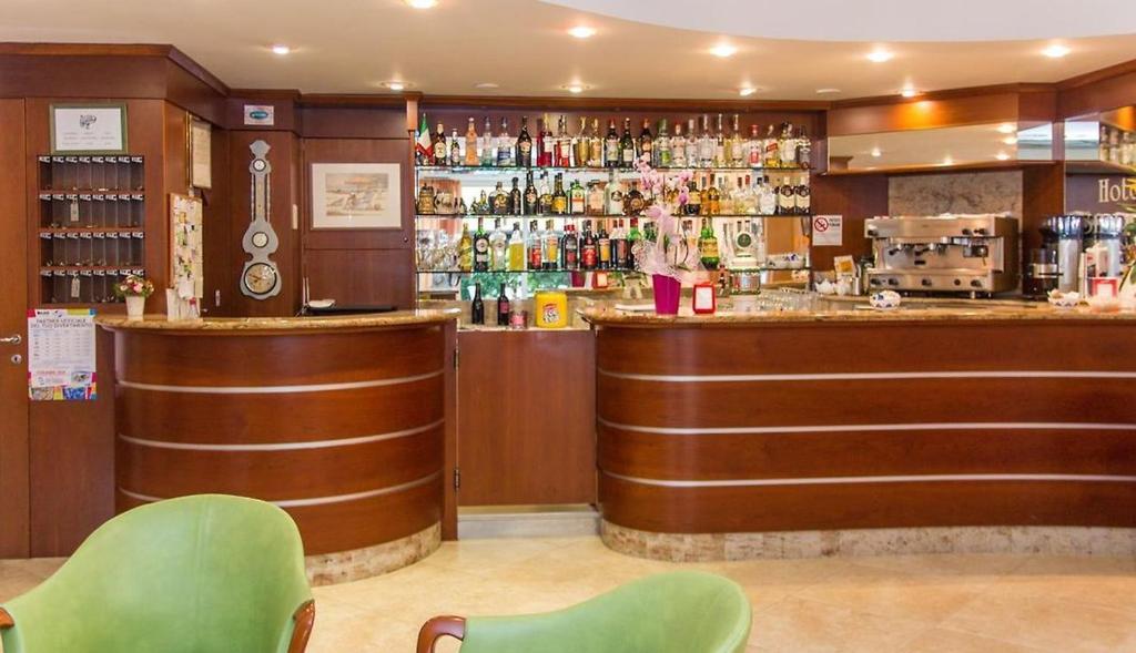 un bar dans un restaurant avec des chaises vertes dans l'établissement Milano Simple, à Bellaria-Igea Marina