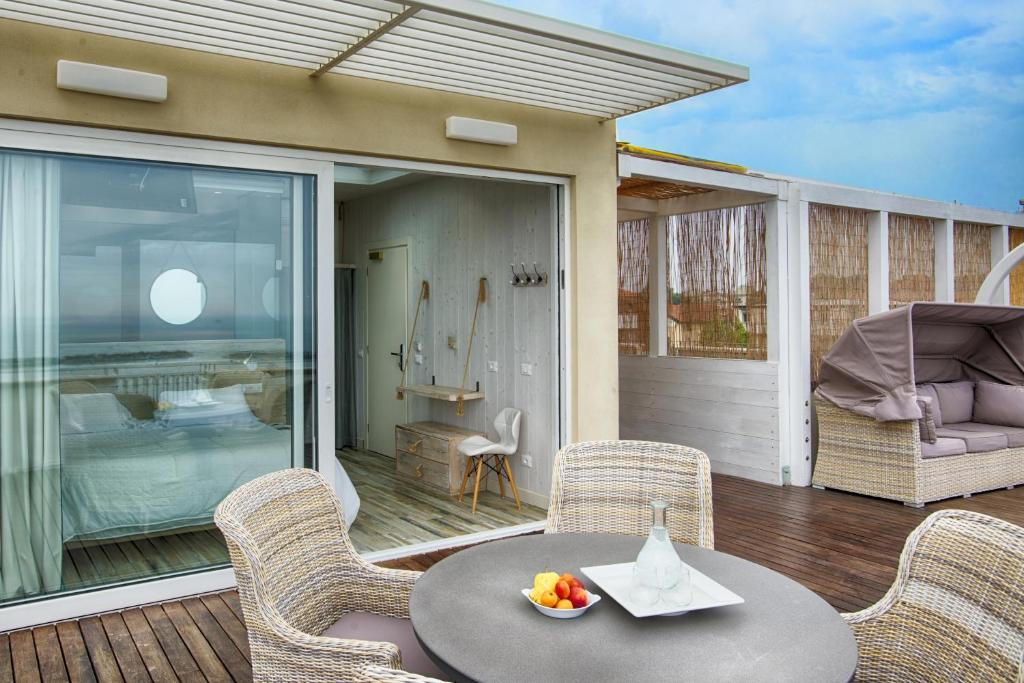 un patio avec une table et des chaises sur une terrasse dans l'établissement Hotel Agostini, à Bellaria-Igea Marina