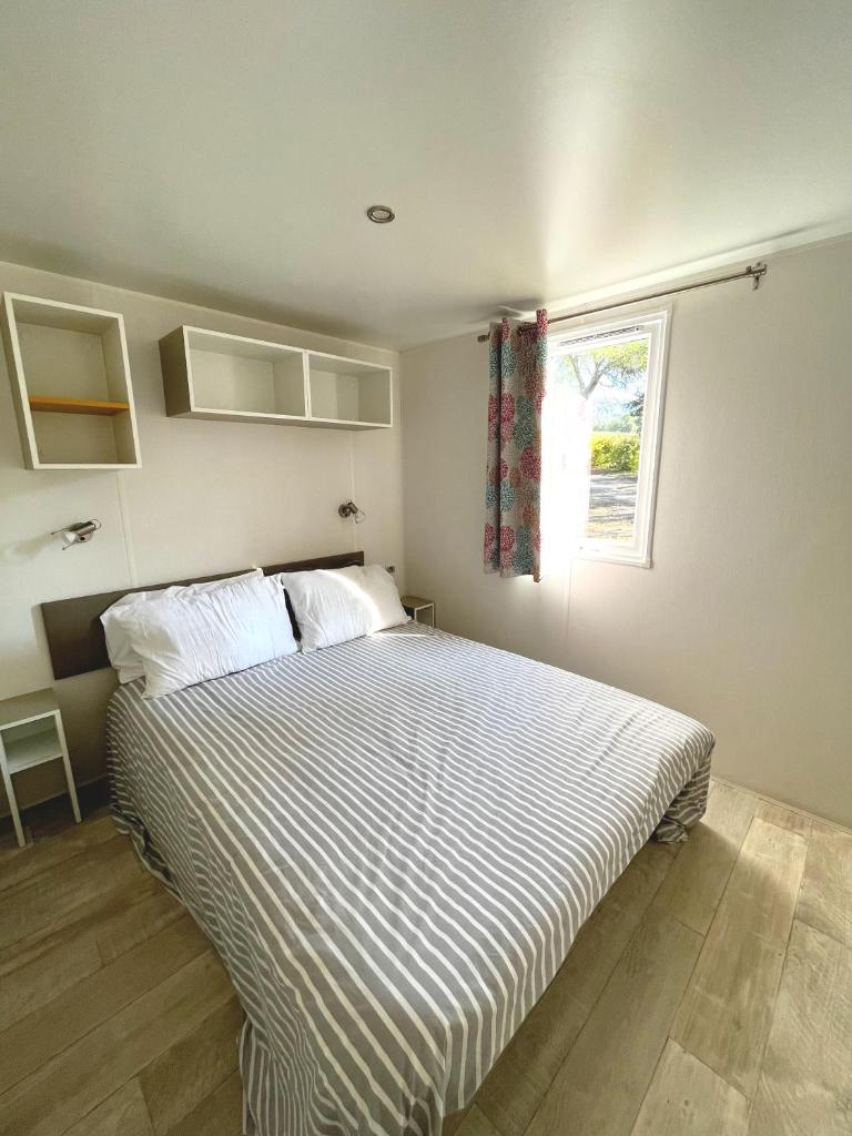 - une chambre avec un grand lit et une couette à rayures dans l'établissement Mobil-home dans camping 4*, à Saint-Laurent-du-Verdon 8 autres photos