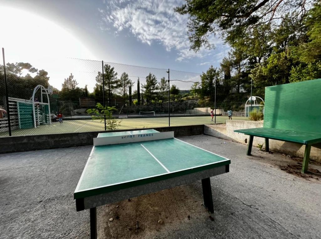 - un court de tennis avec une table verte et un court de tennis dans l'établissement Mobil-home dans camping 4*, à Saint-Laurent-du-Verdon