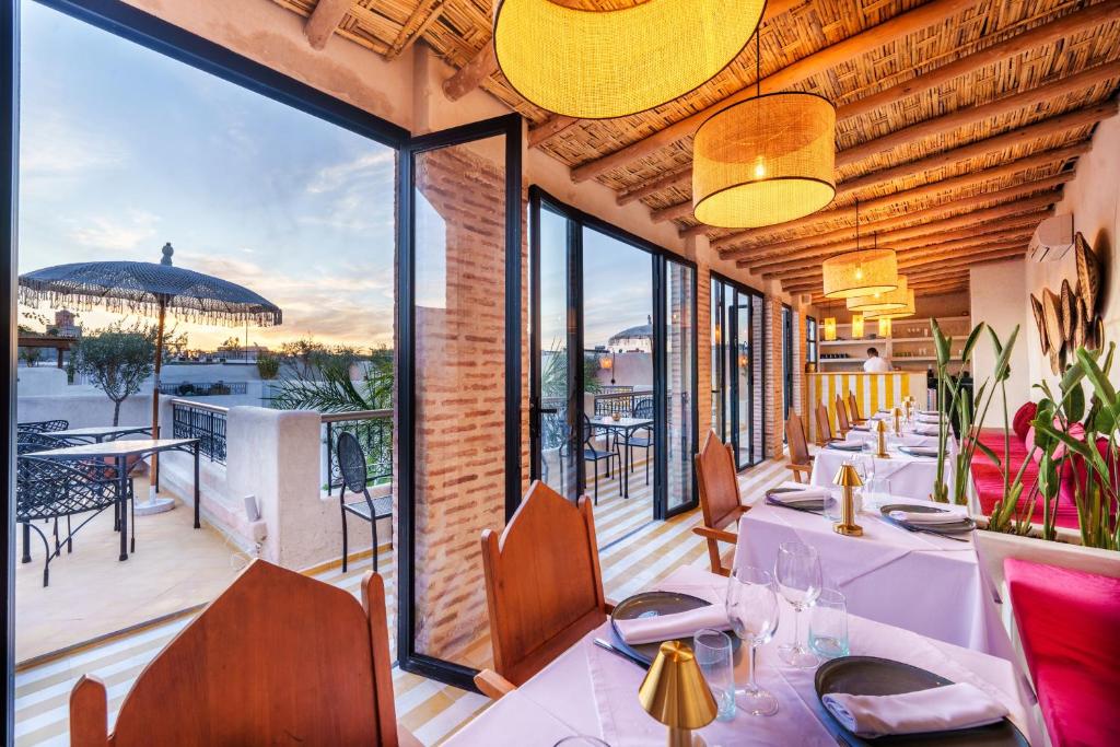 un restaurant avec des tables et des chaises sur un balcon dans l'établissement Riad XO, à Marrakech