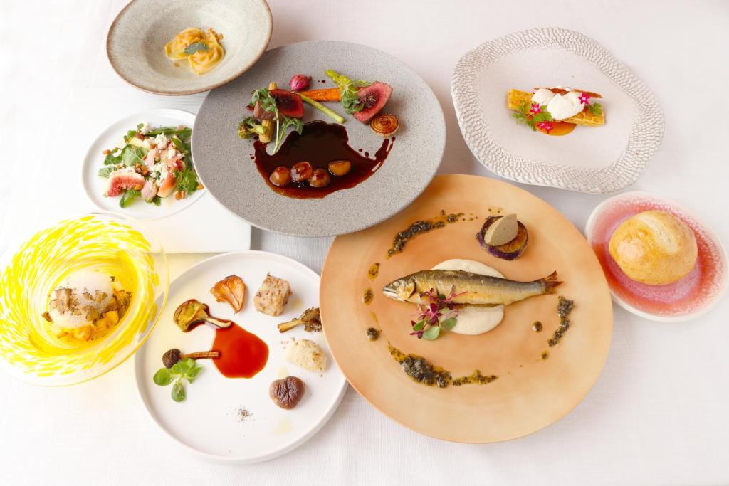 un groupe de plaques alimentaires sur une table dans l'établissement NIPPONIA Chichibu Monzenmachi, à Chichibu