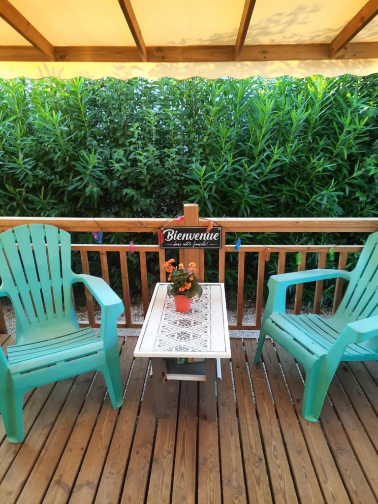 2 chaises et une table sur une terrasse dans l'établissement Mobilhome 8 pers, à Fréjus