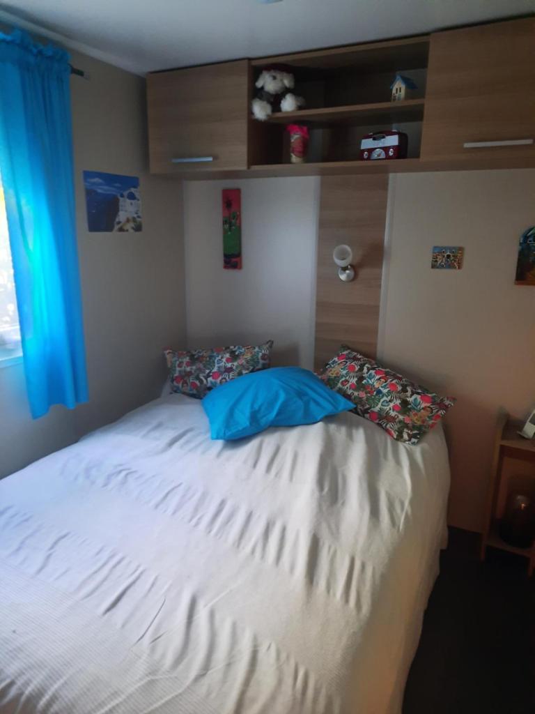 un lit avec deux oreillers dessus dans une chambre dans l'établissement Mobilhome 8 pers, à Fréjus