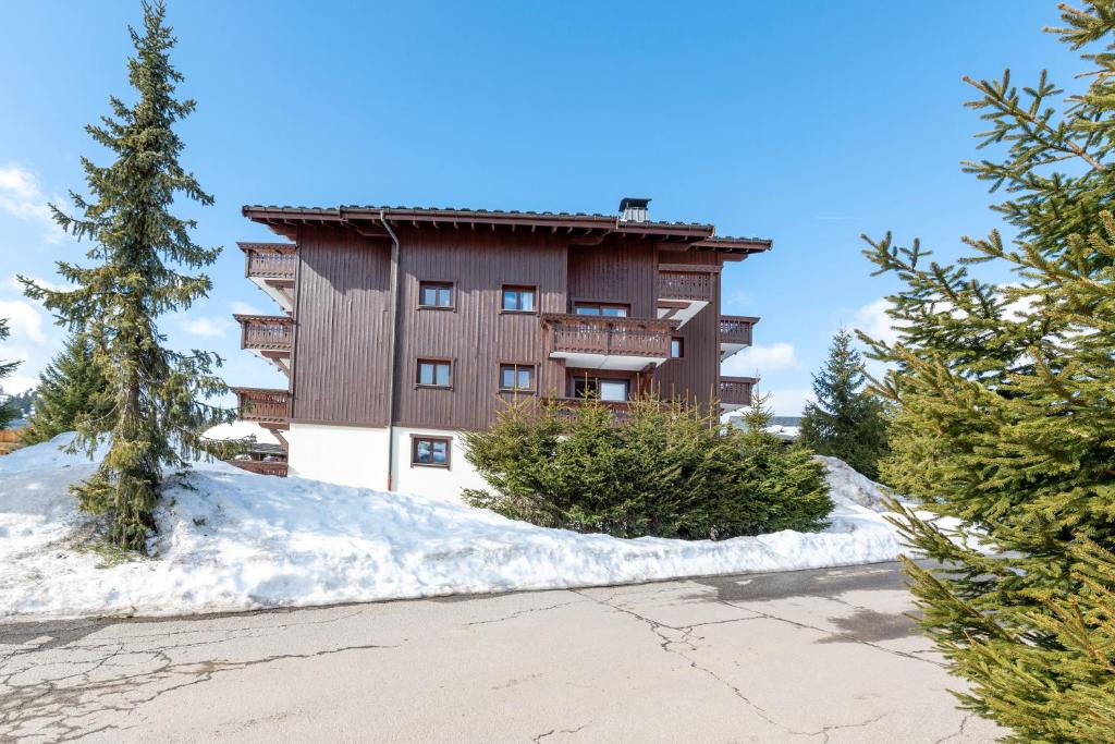 un grand bâtiment avec de la neige devant lui dans l'établissement Lapon H10, à Hauteluce