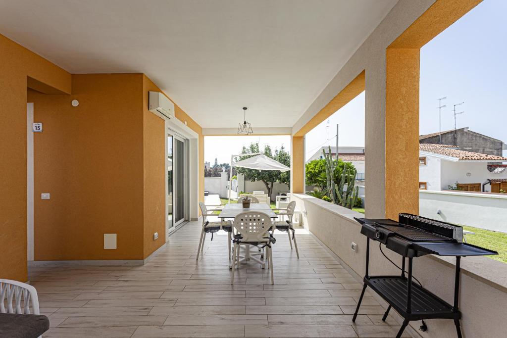 un patio avec une table et des chaises sur un balcon dans l'établissement Luxury Villa Urania with pool - Stella del Mare Fontanebianche, à Fontane Bianche