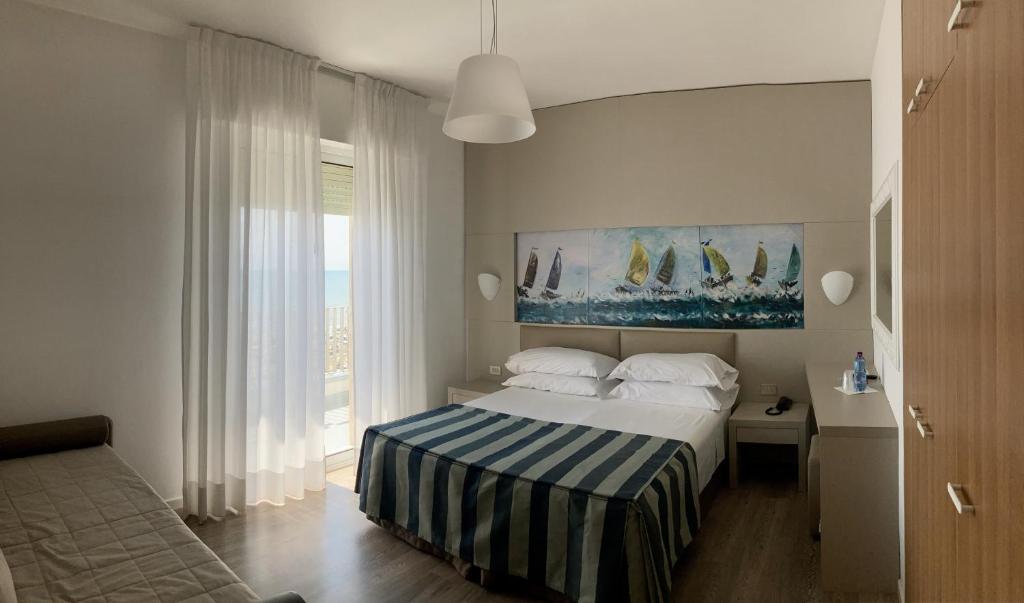 une chambre avec un lit avec un tableau sur le mur dans l'établissement Hotel Sirenetta, à Lido di Jesolo