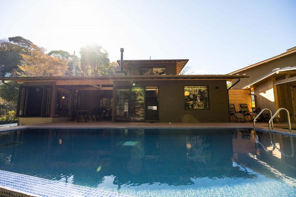 une grande piscine devant une maison dans l'établissement 横川温泉湯殿ととのゆ, à Shimoda