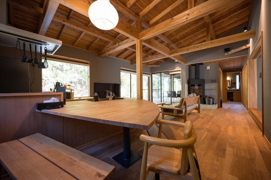 une cuisine et une salle à manger avec une grande table en bois dans l'établissement 横川温泉湯殿ととのゆ, à Shimoda