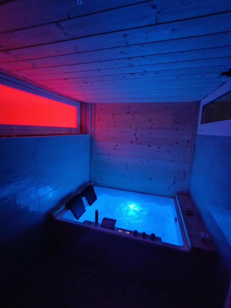 - un bain à remous dans une pièce dotée de lumières rouges et bleues dans l'établissement SUITTINA, exclusive - wellness - living, à Battipaglia 44 autres photos