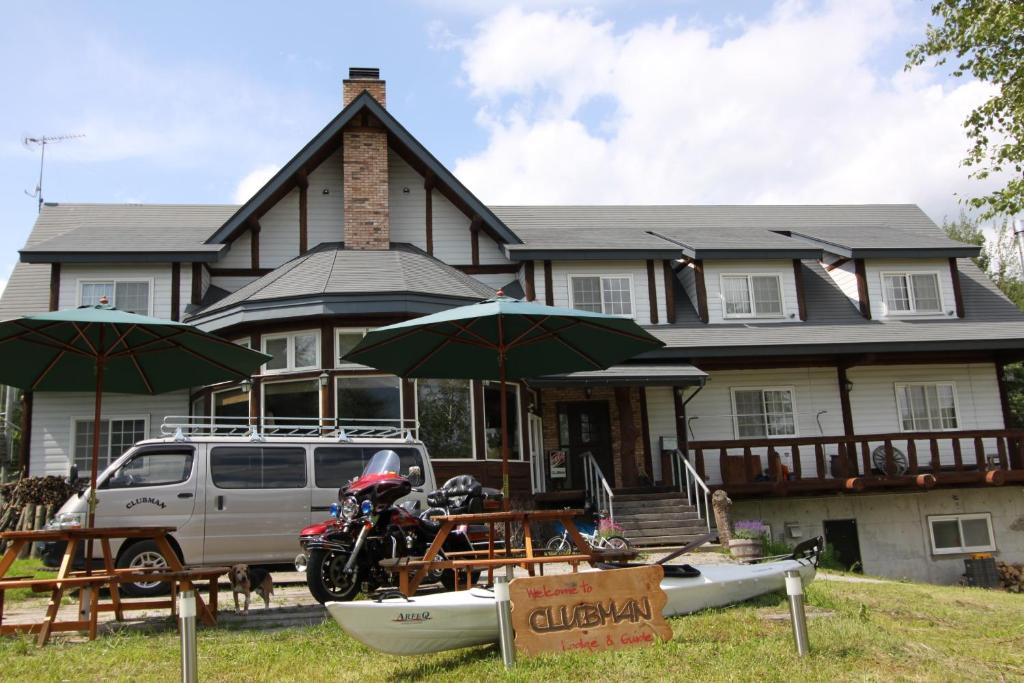 une maison avec une moto garée devant elle dans l'établissement Lodge Clubman, à Hachimantai