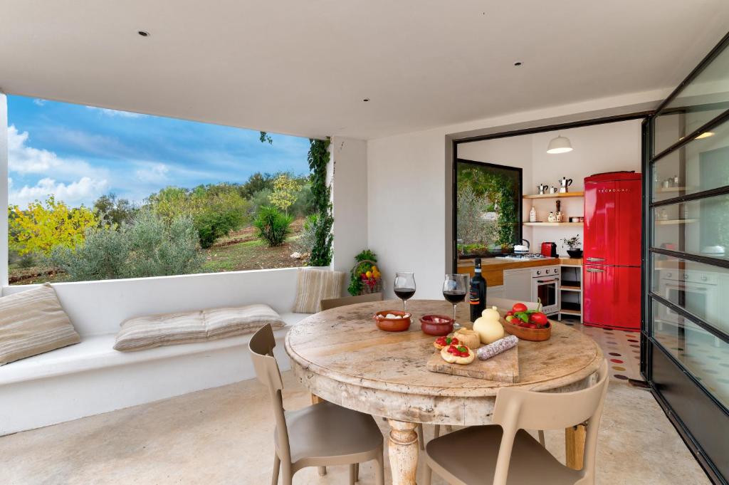 une cuisine et une salle à manger avec une table et des chaises dans l'établissement TRULLO SANTA PAZIENZA 6&3, Emma Villas, à Martina Franca