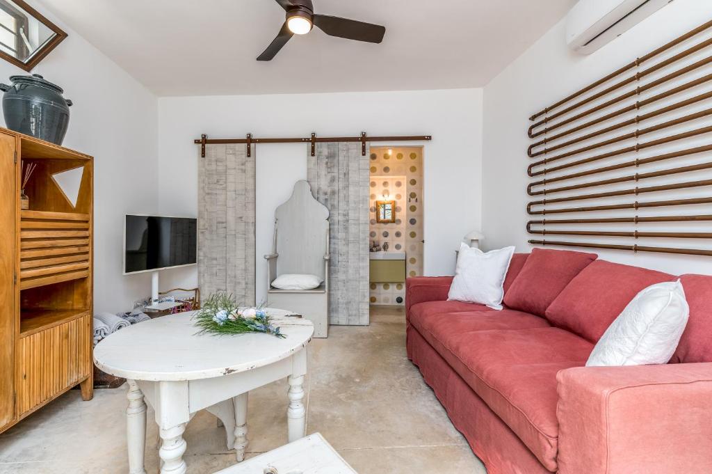 un salon avec un canapé rouge et une table dans l'établissement TRULLO SANTA PAZIENZA 6&3, Emma Villas, à Martina Franca