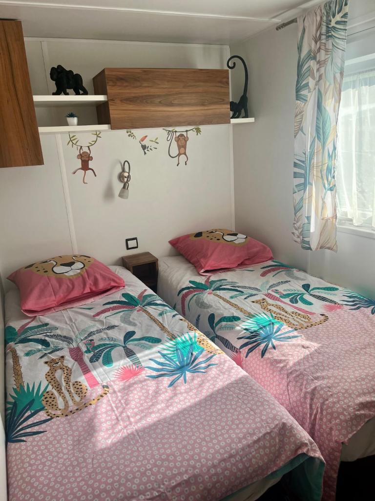 deux lits côte à côte dans une pièce dans l'établissement Mobile home exotique de 40 m2, à Fréjus 19 autres photos